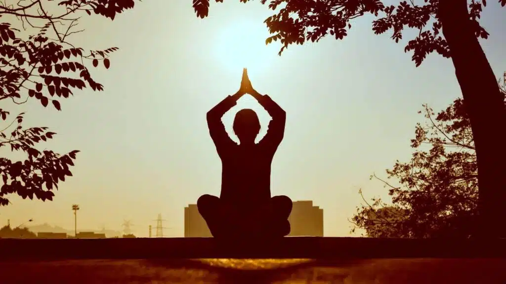 Woman Doing Yoga In Front of The Setting Sun