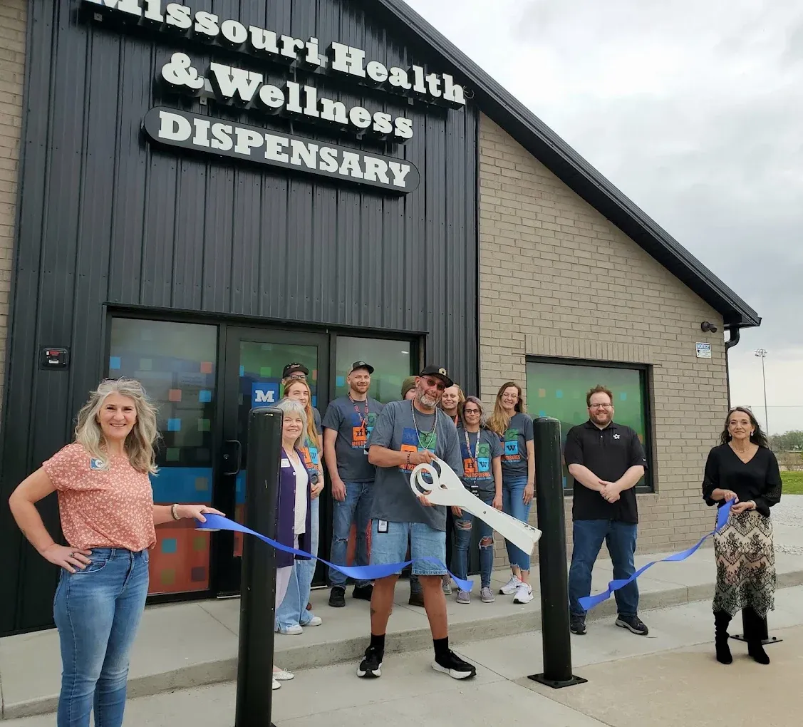 # Alt Text

Group of customers standing outside Missouri cannabis dispensary building entrance