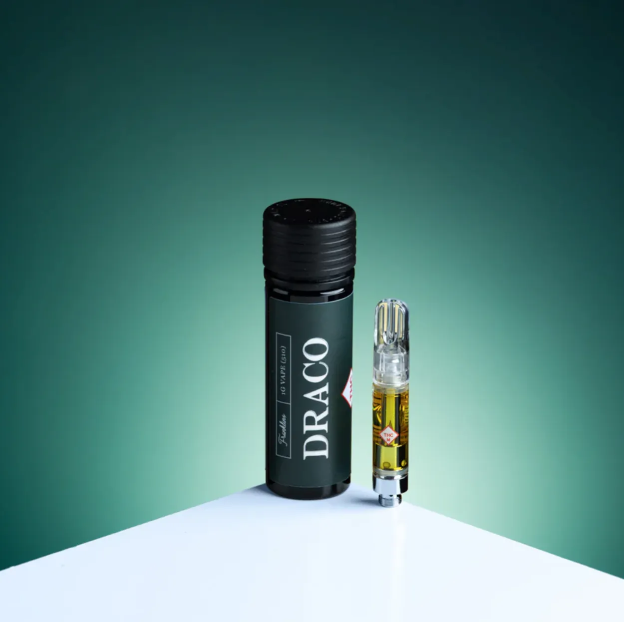 Black cylindrical cannabis product container with gold-labeled vial on white surface, teal background